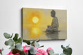 Framed canvas print of a meditative figure with the sun setting over water, reflecting golden tones