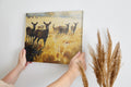 Framed canvas print of a deer herd in a golden autumn landscape with splattered paint effect.