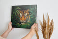Canvas print of a tiger in a jungle with vivid green leaves around it