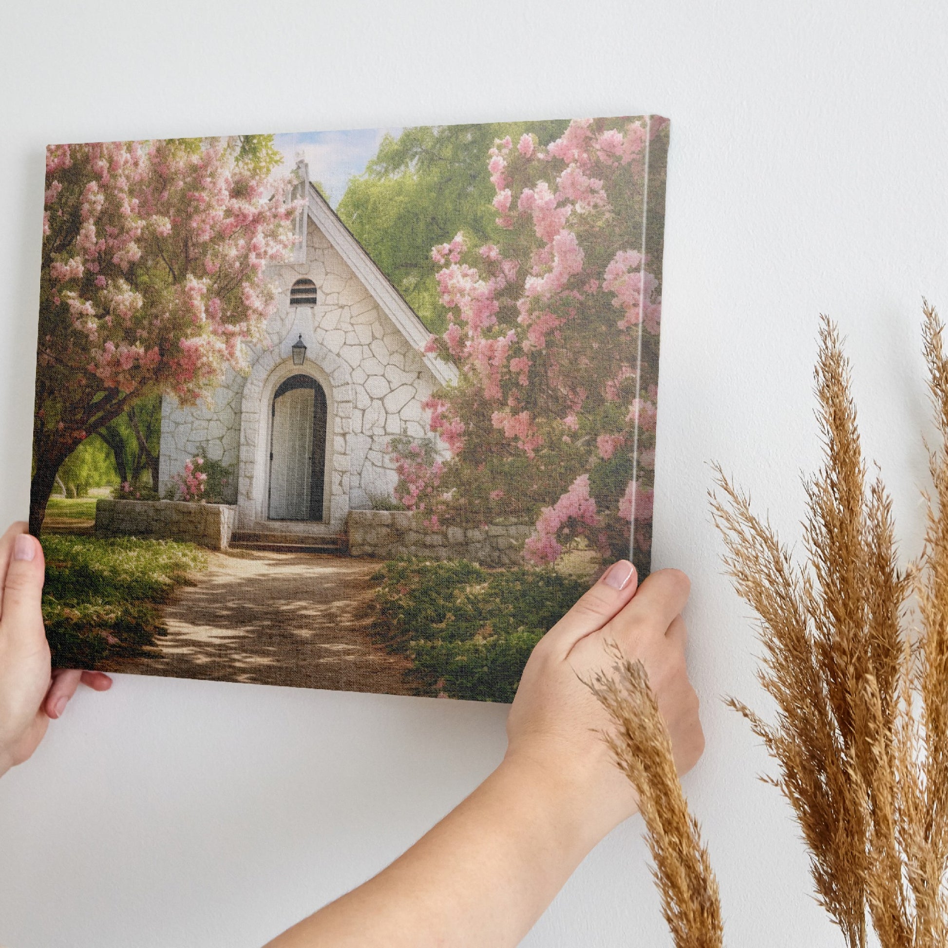 Framed canvas print of a chapel surrounded by lush pink blossom trees