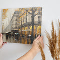 Framed canvas print of a Parisian streetscape with autumn leaves and rain