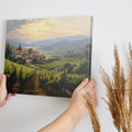 Framed canvas print of a Tuscan vineyard at sunset with warm golden hues and terracotta houses