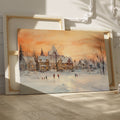 Framed canvas print of a snowy Victorian village at sunset with people ice skating