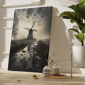 Framed canvas print of a misty Dutch windmill landscape with dramatic sky and reflection in puddle