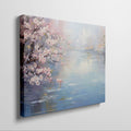 Framed canvas print of a serene impressionist painting with cherry blossoms and river reflections