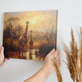 Framed canvas print of a family of giraffes in the savannah during sunset with warm tones