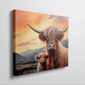 Framed canvas print of Highland cattle with calf at sunset, warm tones and mountain backdrop