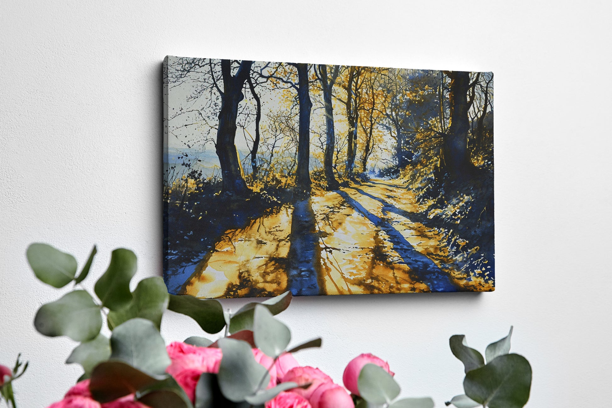 Framed canvas print of a sunlit forest pathway with golden tones and tree silhouettes