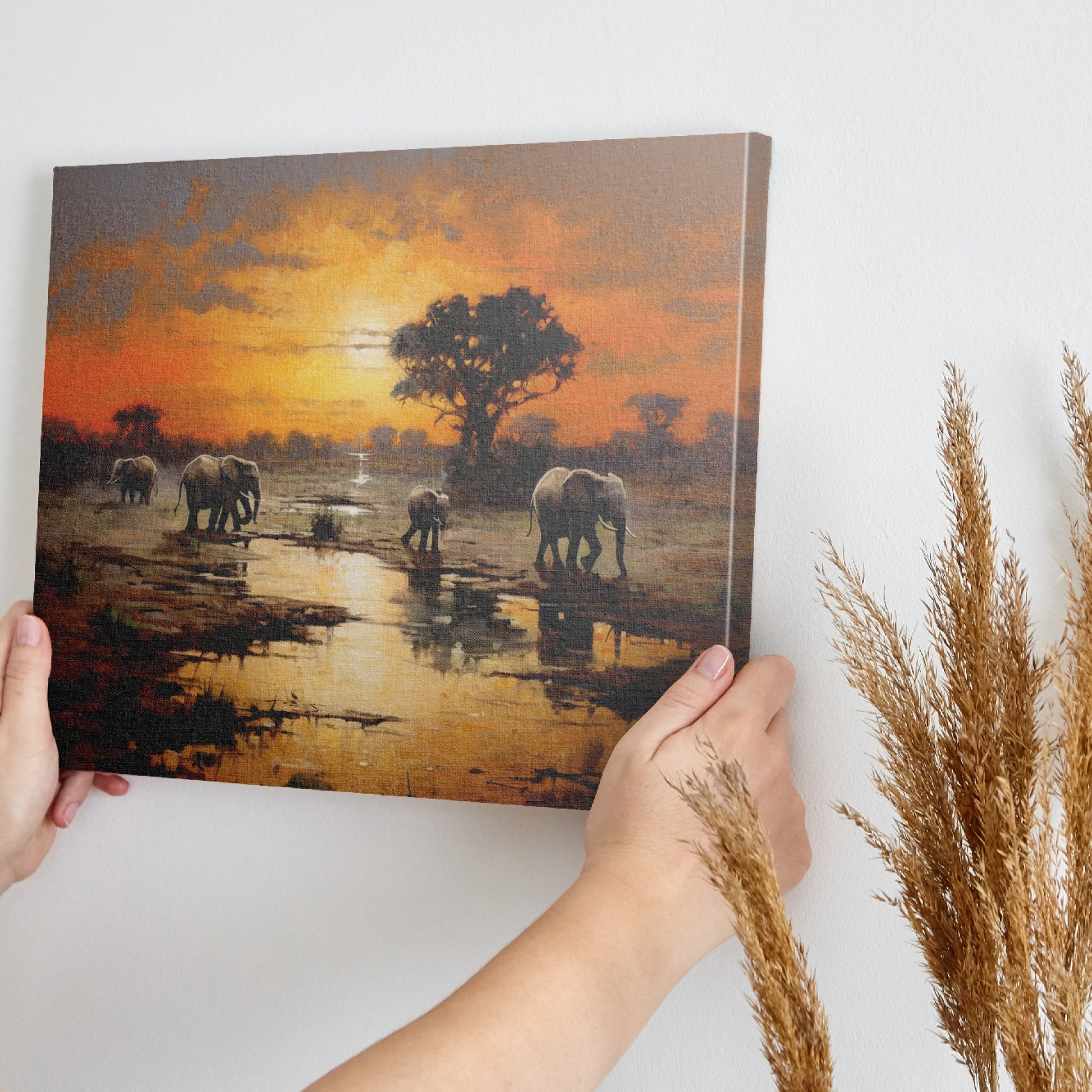 Framed canvas print of African elephants walking beside water during a vibrant sunset