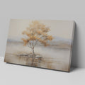 Framed canvas print of a solitary tree with autumn leaves reflected on a calm lake with warm beige, gold, and white tones