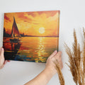 Framed canvas print of an impressionist sailboat against a vivid sunset