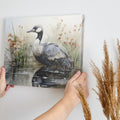 Framed canvas print of a crane amongst reeds in a watercolor wetland scene with neutral tones