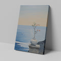 Canvas print of a tranquil ocean view with a blossoming plant in a vase on a ledge