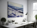 Framed canvas print of a snowy countryside landscape with rolling hills in cool blue tones