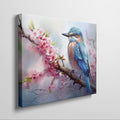 Framed canvas print of a vibrant kingfisher on a flowering cherry blossom branch