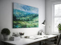 Framed canvas print of a watercolour countryside landscape with green rolling hills and vibrant skies