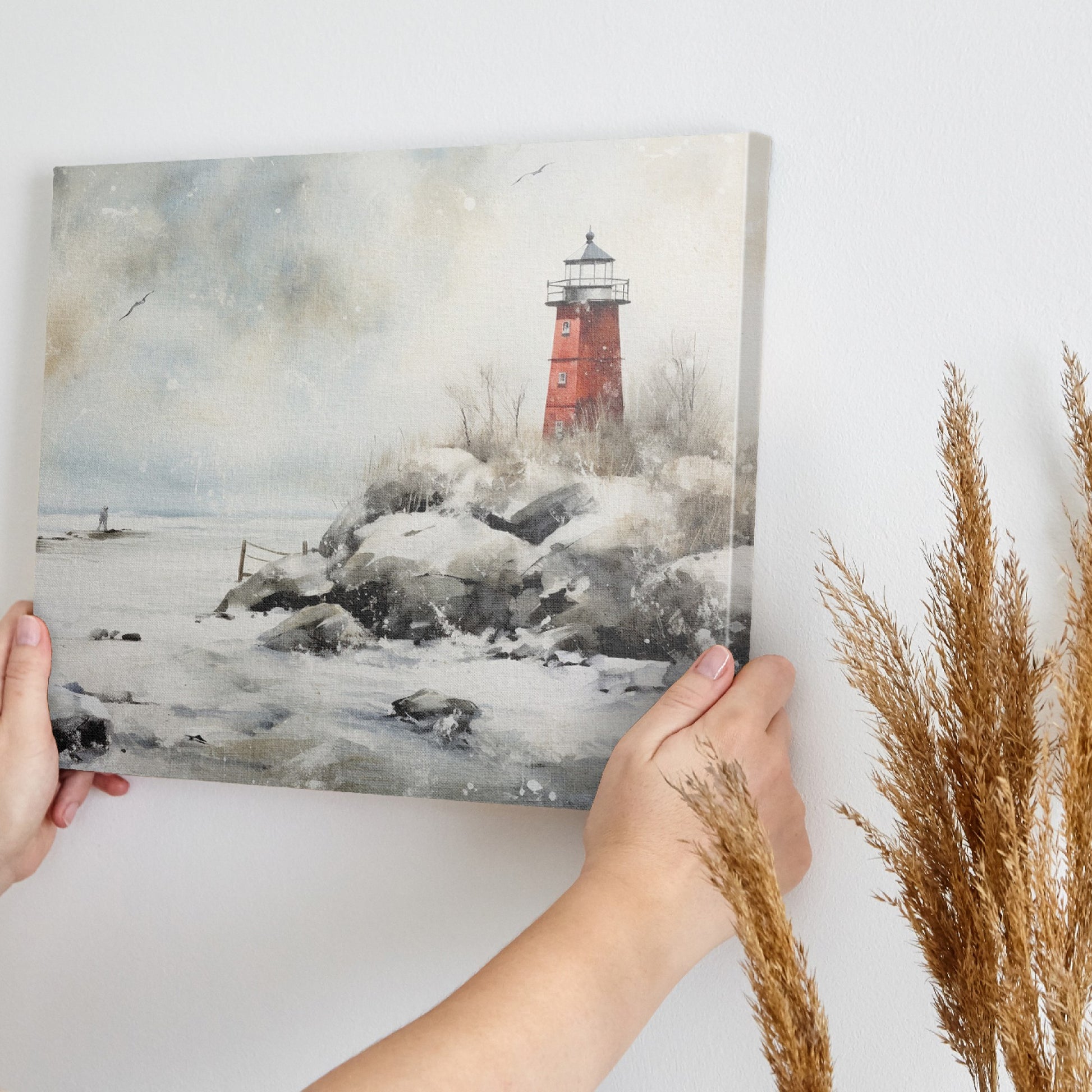 A red lighthouse on a snowy coastline with a figure at a distance and seagulls in the wintry sky.