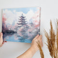 Framed canvas print of a Japanese pagoda surrounded by cherry blossoms and reflected in a tranquil pond