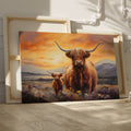 Framed canvas print of a Highland Cow and Calf against a vivid sunset landscape