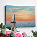 Sailboat on calming ocean waters during a vibrant sunset with orange and pink clouds in the sky.