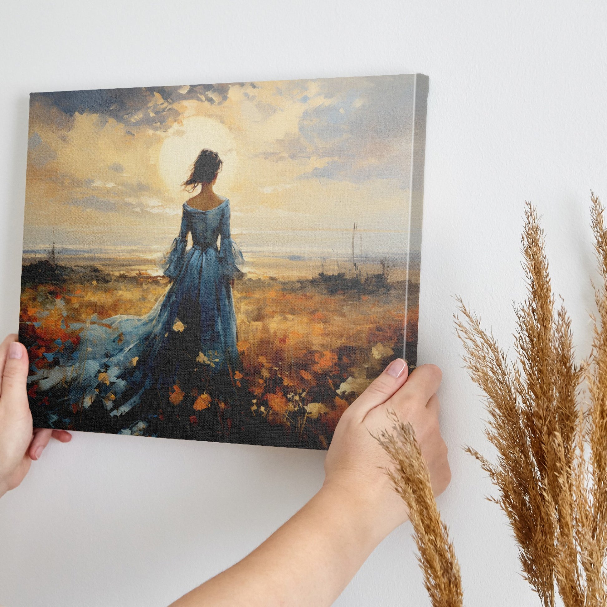 Framed canvas print of an elegant lady in a blue dress against a rural sunset backdrop with warm hues and a dramatic skyline