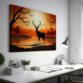 Printed canvas art of a black deer silhouette against an orange sunset with trees and mountains