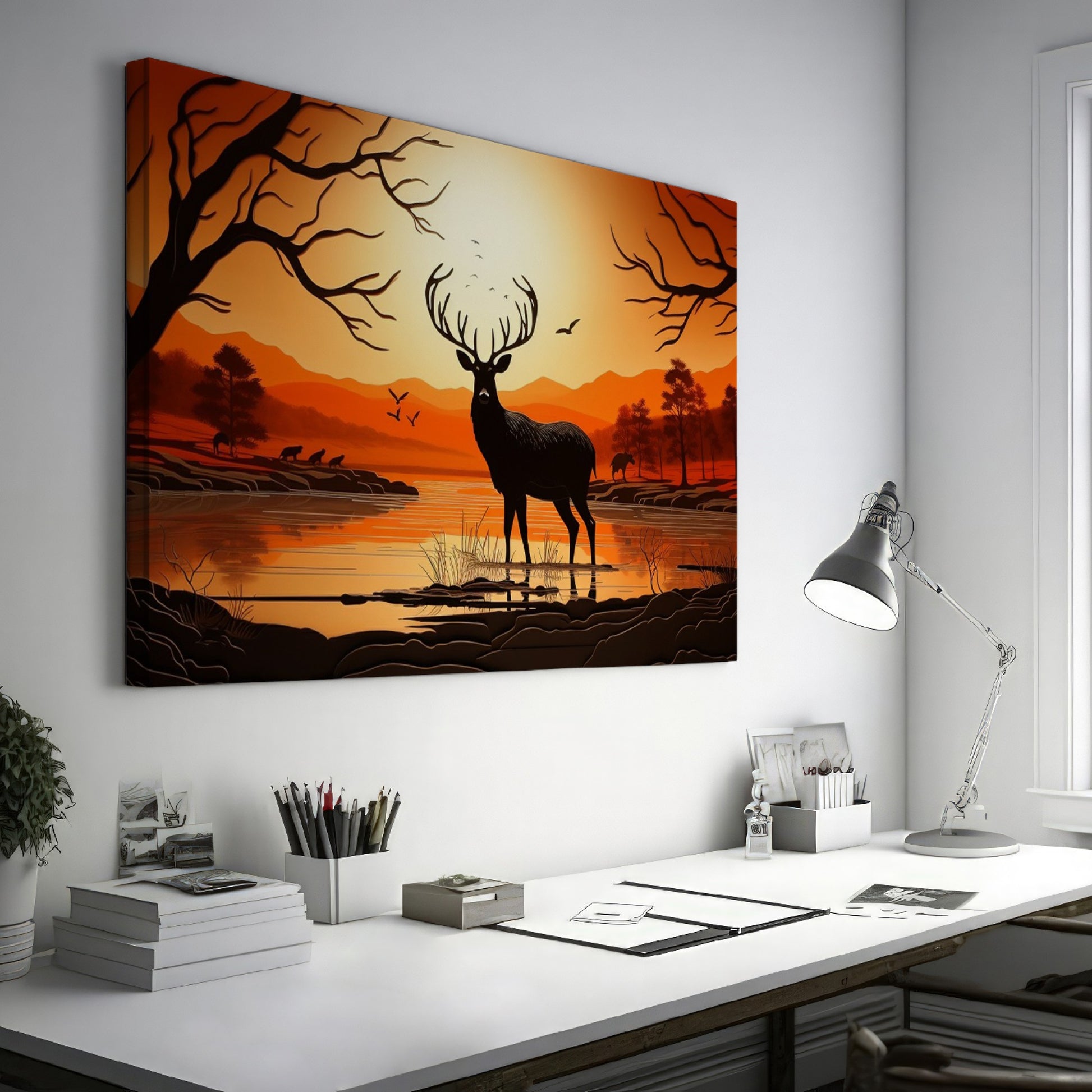 Printed canvas art of a black deer silhouette against an orange sunset with trees and mountains