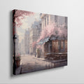 Framed canvas print of a Parisian cafe on a cobblestone street with cherry blossoms in full bloom