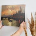 Framed canvas print of London's Westminster and Big Ben at sunset with orange and warm tones reflecting on the Thames River