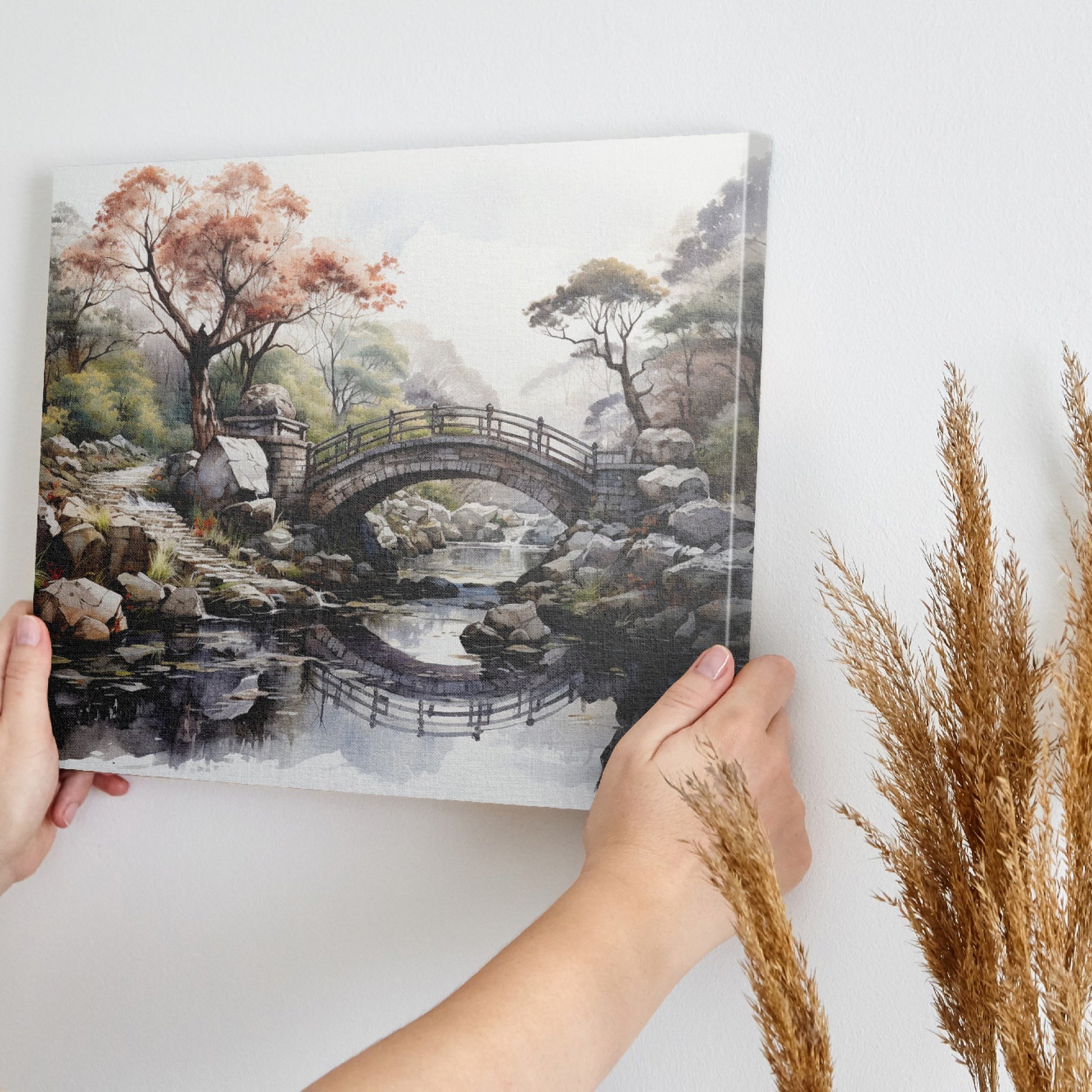 Framed canvas print of an autumnal stone bridge over a serene stream, surrounded by trees with watercolour details