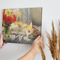 Framed canvas print of a ginger cat sleeping beside vibrant red tulips and yellow daffodils