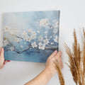 Framed canvas print of elegant white blossoms on a serene blue background with impasto textures