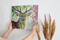 Framed canvas print of a vibrant stag with colourful floral surroundings