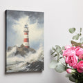 Framed canvas print of a lighthouse on rocky shores with turbulent waves and stormy sky