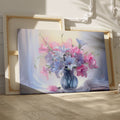 Framed canvas print of a realistic floral still life with pastel pink and blue flowers in a vase