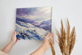 Framed canvas print of a snowy mountain landscape in watercolour with shades of purple and blue