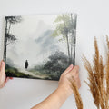 Framed canvas print featuring a solitary figure walking through a misty, ethereal bamboo forest cast in a monochrome colour scheme