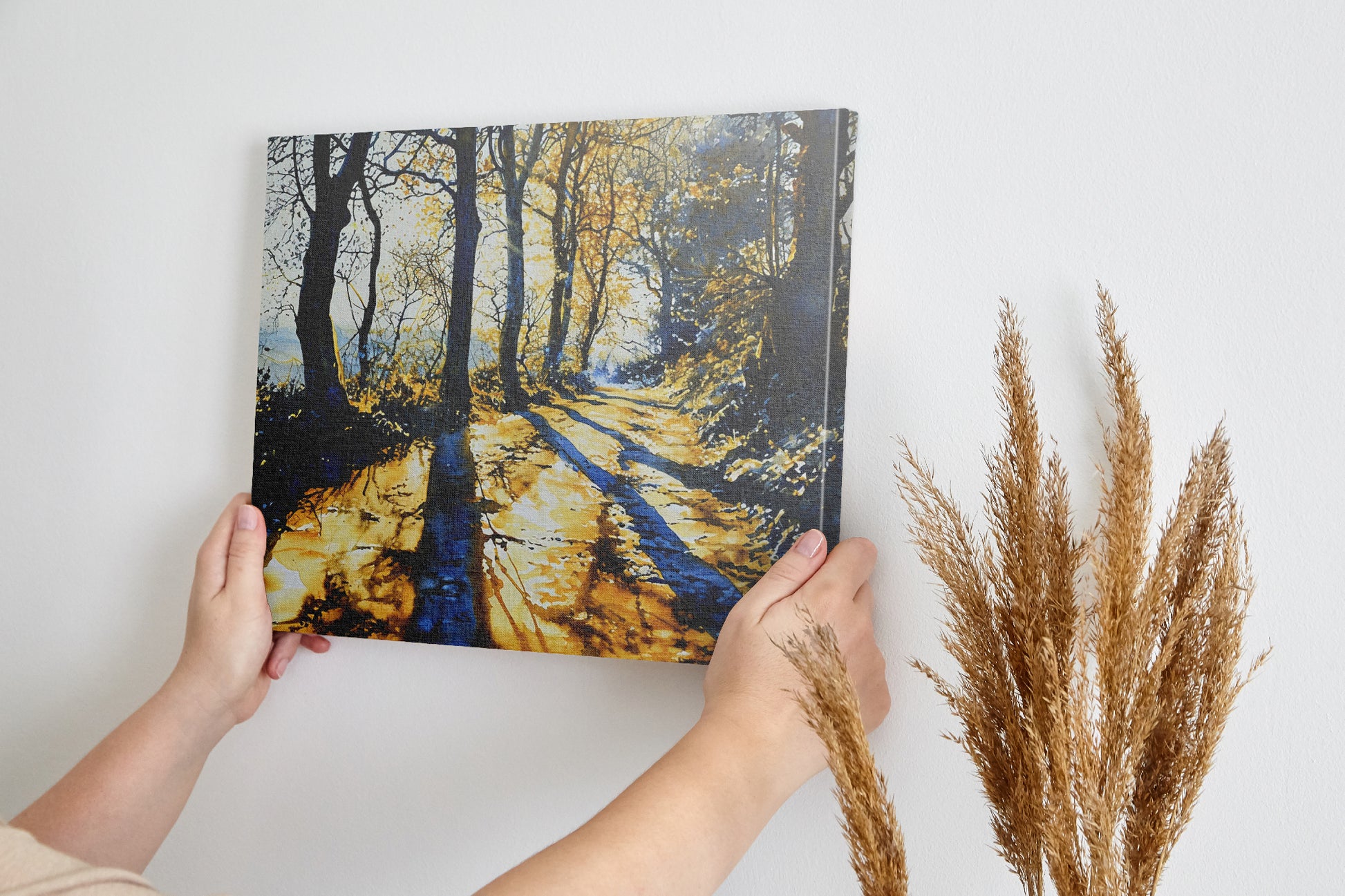 Framed canvas print of a sunlit forest pathway with golden tones and tree silhouettes