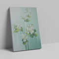 Framed canvas print of white blossoms with green leaves on a soft blue background