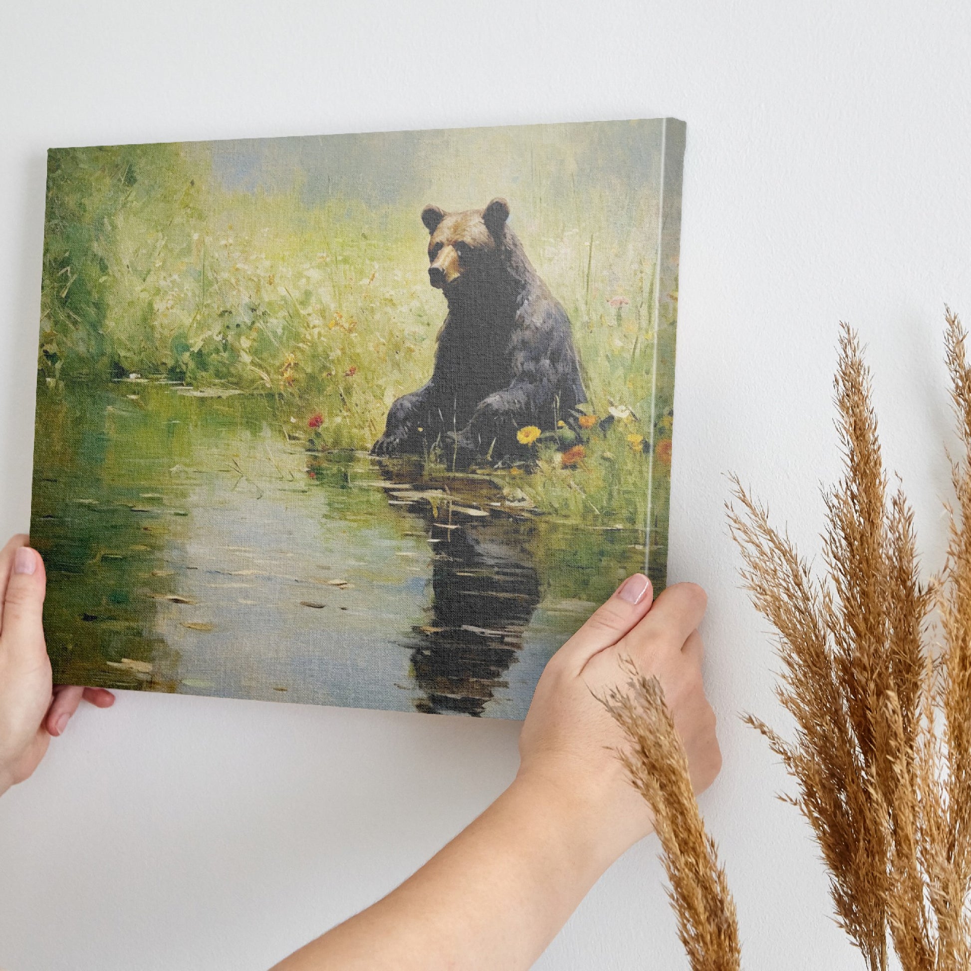 Framed canvas print of a bear sitting by a pond with floral surroundings