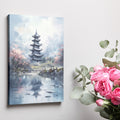 Framed canvas print of an impressionist painting showing a pagoda and cherry blossoms with reflections in water