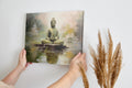 Framed canvas print of a serene Buddha sitting in meditation with a reflective water effect