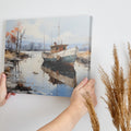 Framed canvas print of a tranquil landscape with a vintage boat moored on calm waters, reflecting autumnal trees