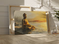 Wall canvas print of a meditative Buddha statue in golden and orange hues reflecting on tranquil waters at sunrise.