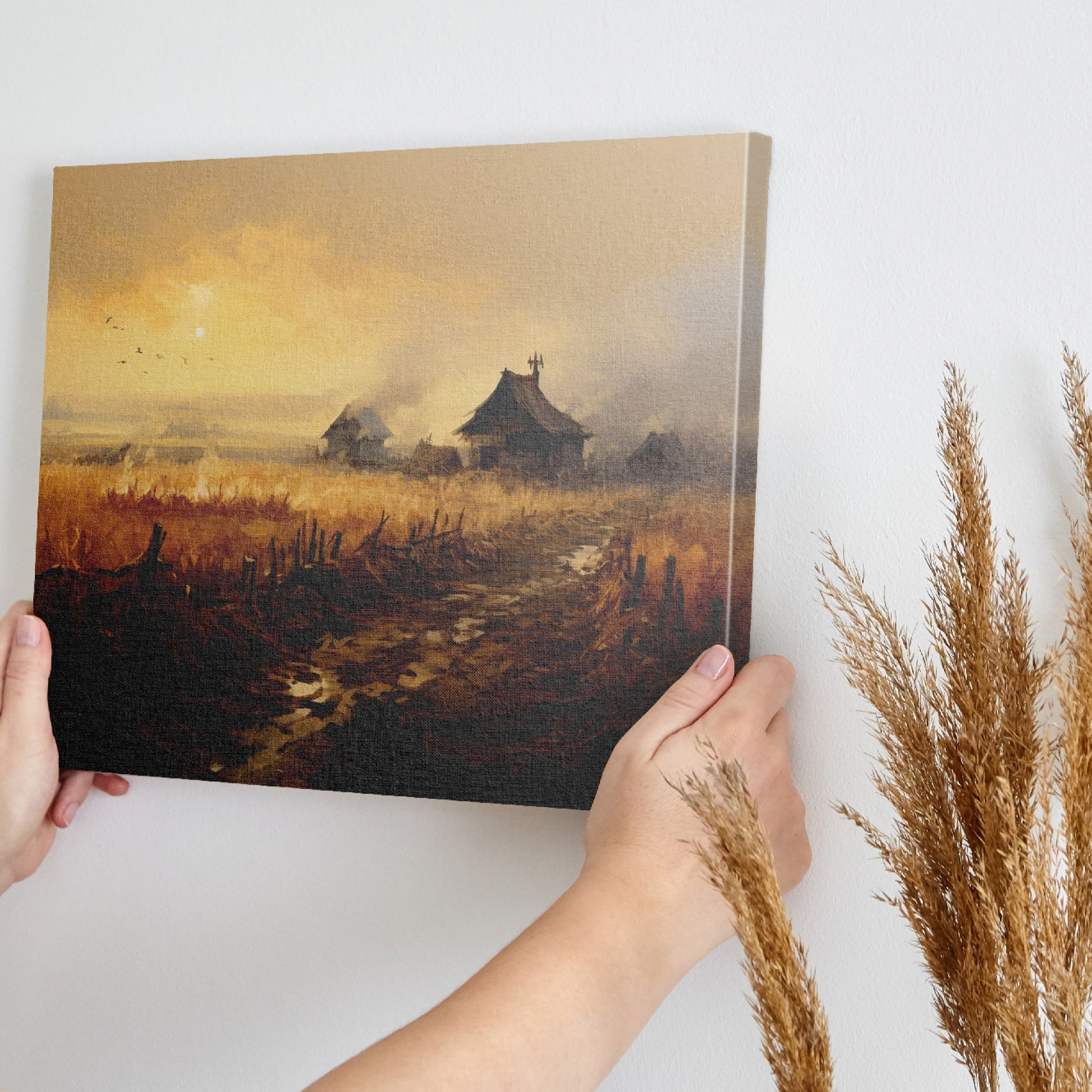 Framed canvas print of a rustic countryside at sunset with golden fields and cottages