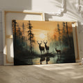 Framed canvas print of deer silhouetted against a forest sunset with reflections on water