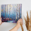 Framed canvas print of a stylised geometric birch forest in vibrant blue, purple, and yellow tones