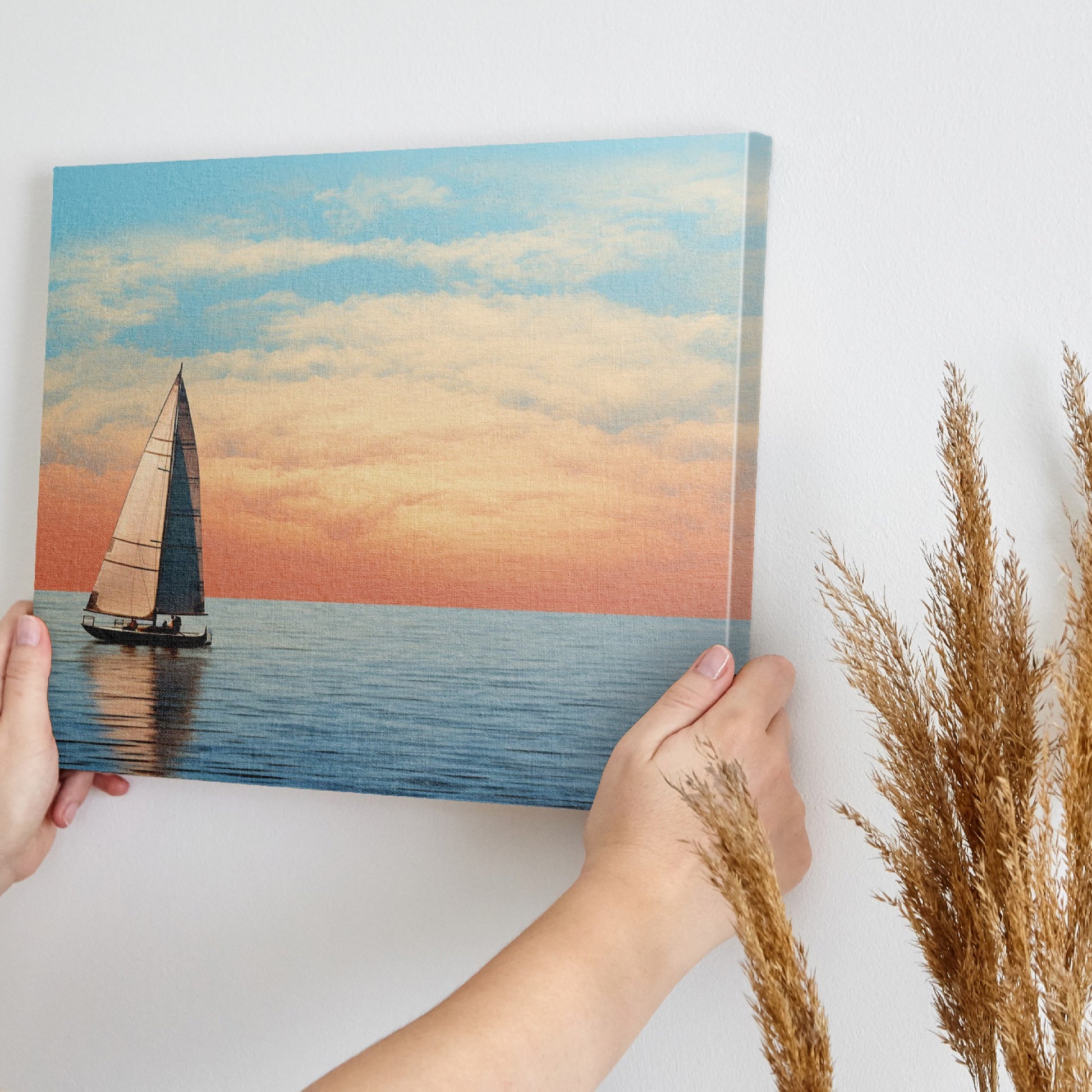 Sailboat on calming ocean waters during a vibrant sunset with orange and pink clouds in the sky.