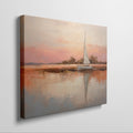 Framed canvas painting of a sailboat at sunset with orange and beige sky reflected in calm blue waters