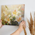 Framed canvas print of serene white lilies with a warm colour palette and lush greenery